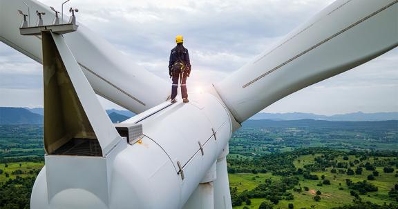 Inspection engineers standing on top of a wind turbine and looking at a landscape